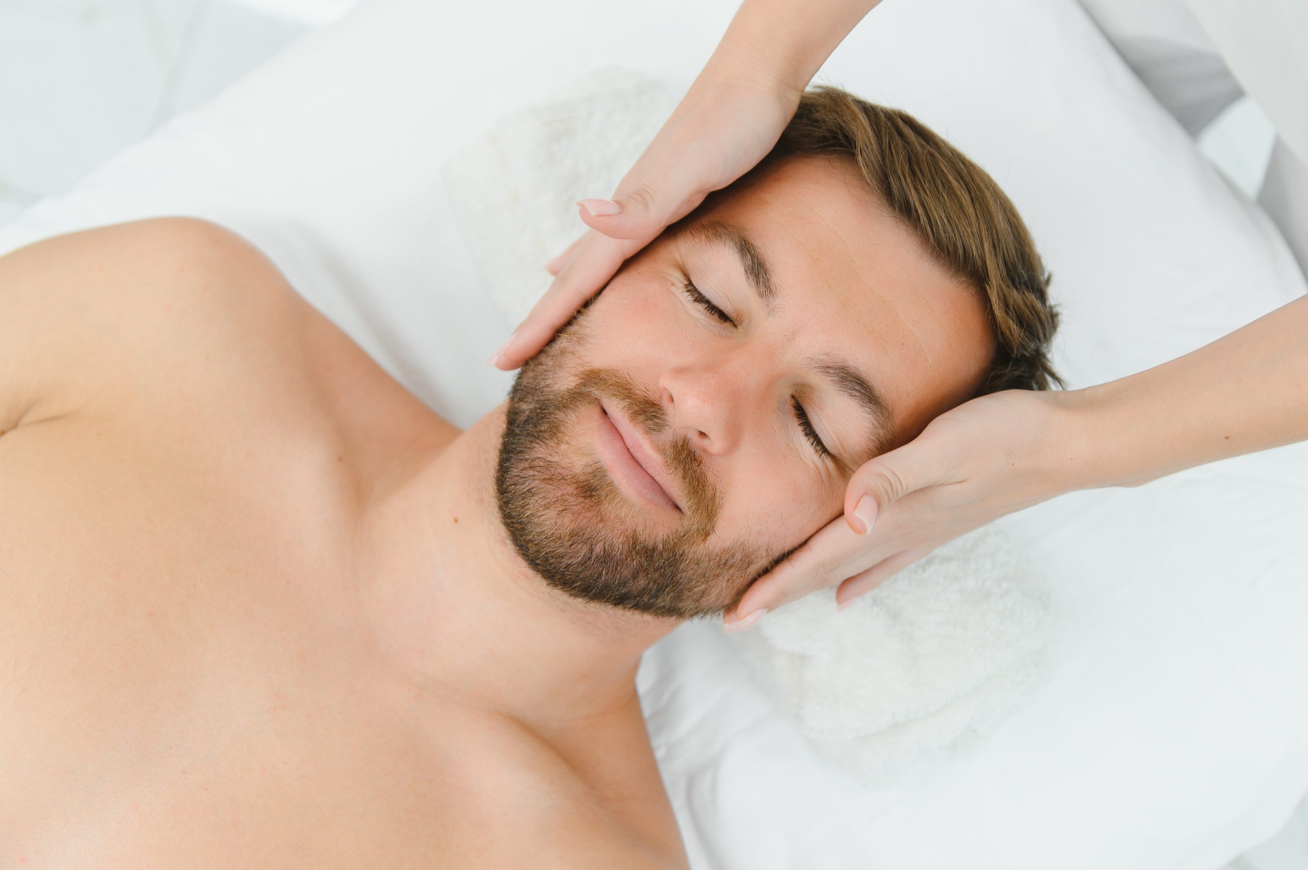 Spa therapist making relaxing massage for handsome man. Male cosmetology concept